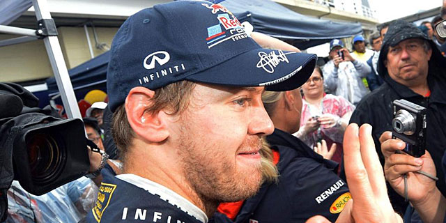 Sebastian Vettel seala con sus dedos sus tres campeonatos del mundo. | Efe