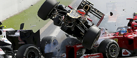Romain Grosjean 'aterriza' sobre el Ferrari de Alonso. | EFE