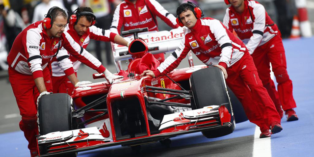 Mecnicos remolcando el coche de Alonso durante el GP de Alemania. | Reuters