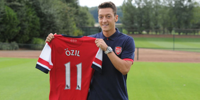Mesut zil posa con la camiseta del Arsenal.