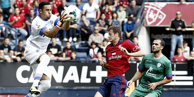 Keylor Navas (i), detiene el baln ante su compaero Loukas Vyntra (d) y ante el jugador de Osasuna Oriol Riera. | Efe