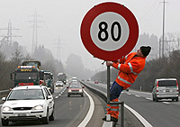Un operario coloca una seal con la nueva limitacin de la velocidad, en la autopista N-4, a su paso por la localidad de Zug.