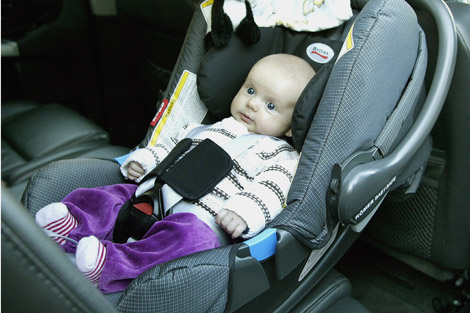 Imagen de un bebé sujeto por un sistema de retención