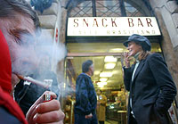 Varias personas encienden un cigarro a las puertas de un bar de Roma (Foto: AP)