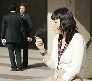Una mujer fumando en la entrada de un edificio de Madrid (Foto: Diego Sinova)