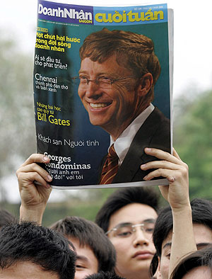 Estudiantes en Hanoi (Vietnam) muestran una foto de Bill Gates en la portada de una revista. (Foto: AFP | Hoang Dinh)