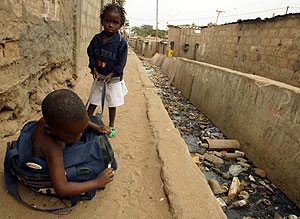 Dos nios juegan en un barrio de Luanda junto a aguas contaminadas (Foto: W. Conradie | Reuters)