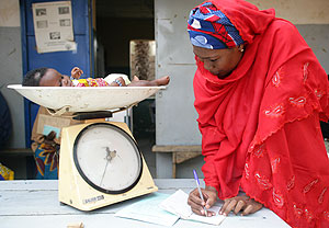 Una mujer toma nota del peso de un beb en un dispensario en Nger (Foto: Unicef)