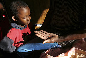 Un nio observa los frmacos de su padre para el sida. (Foto: Reuters)