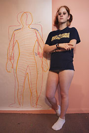 Britanny junto al dibujo (en rojo) que ha hecho de su cuerpo. La parte coloreada son sus dimensiones reales