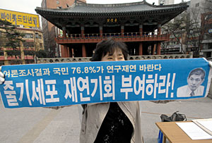 Un ciudadano sostiene una pancarta a favor de Woo-suk Hwang. (Foto: AFP | Jung Yeon)