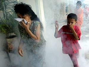 Dos indonesios se cubren la cara para no respirar un repelente de mosquitos rociado en Yakarta (Foto: Bagus Indahono | EFE)