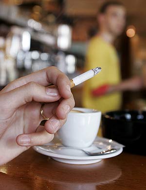 Una mujer fuma en una cafetera. (Foto: Benoit Tessier | Reuters).