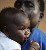 Un padre acuna a su hijo en una maternidad al norte de Uganda (Foto: Euan Denholm | Reuters)