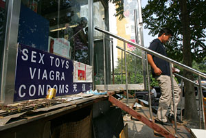 Un joven sale de una tienda que vende viagra en Pekín (China). (Foto: Greg Baker | AP)