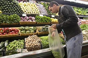 Un hombre elige verduras al hacer la compra. (Foto: AP)