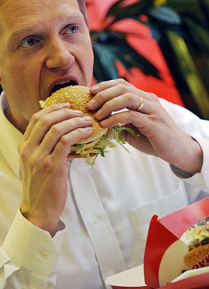 El director de McDonalds en Hungra come una hamburguesa de su restaurante. (Foto: Attila Kisbenedek | AFP)