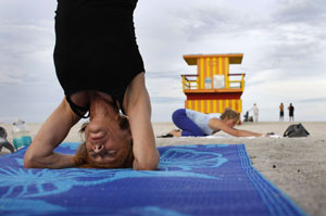 Una mujer practica yoga en una playa de Florida. (Foto: AFP)
