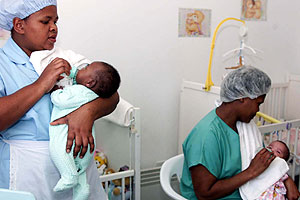 Dos enfermeras dan el biberón a dos bebés enfermos de sida. (Foto: AP)