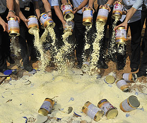 Varios inspectores tiran leche en polvo a un contenedor (Foto: Reuters)