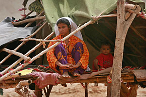 Una madre con su hijo en una de las viviendas semicubiertas de Paquistn (Foto: Athar Hussain)