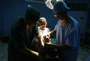 Dos cirujanos preparan a un nio para su circuncisin en Argelia. (Foto: REUTERS)