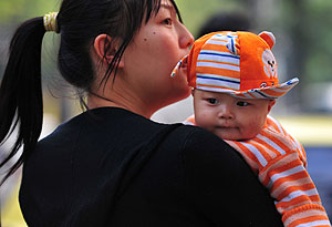 Una mujer lleva a su hijo a un hospital de Pekín. (Foto: Frederic J. Brown | AFP)