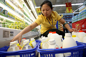 Una trabajadora retira productos lácteos en un supermercado en Wuhan. (Foto: D.Wong | EFE)