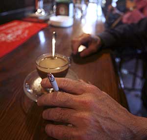 Un cliente fuma mientras se toma un caf en un bar. (Foto: Jos Ayma)