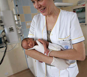 Una enfermera lleva en brazos a un recin nacido en un hospital de Polonia. (Foto: Reuters)