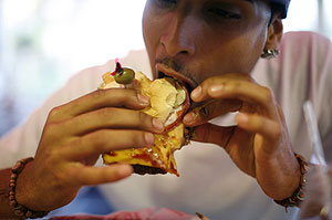 Un joven toma una hamburguesa en Estados Unidos. (Foto: Carlos Barria | REUTERS)