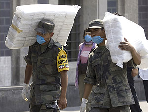 Dos soldados mexicanos llevan paquetes con mscaras para la poblacin en la capital. | Reuters