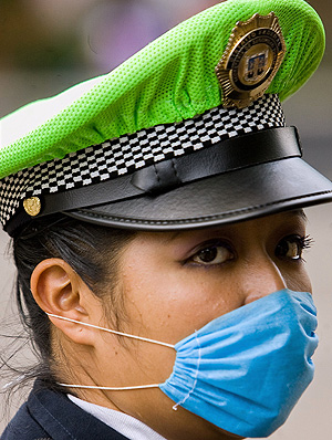 Una oficial de policía se protege en México DF con mascarilla (Foto: AFP | Alfredo Estrella)