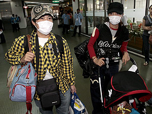 Dos pasajeros se protegen al llegar al aeropuerto de Manila. (Foto: EFE)