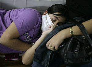 Una chica con mascarilla para evitar la gripe A descansa en Paraguay. (Foto: Ap)