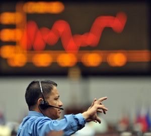 Un financiero gesticula ante una pantalla con uno de los ndices econmicos en Manila. (Afp)