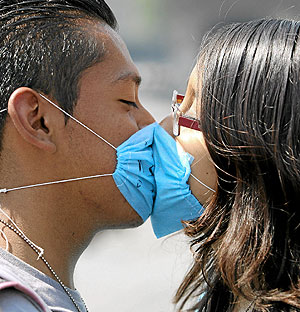 Una pareja con mascarillas se besa en México. (Foto: Efe)