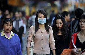 Una mujer lleva mascarilla mientras camina por una calle comercial del centro de Cantón, China. (Foto: Wu Hong | EFE)