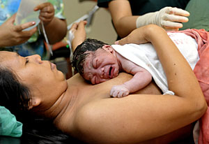 Una mujer filipina sostiene a su bebé tras dar a luz. (Foto: Jay Directo | AFP)