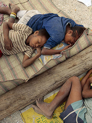 Nios filipinos descansan durante su dura jornada de trabajo, con la que ayudan a sus familias. (EFE)