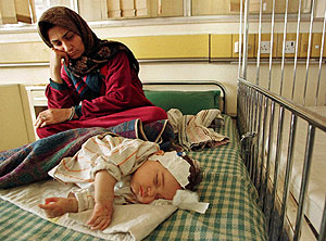 Una mujer iraqu observa a su beb, enfermo de leucemia, en el Hospital Infantil Saddam de Bagdad. (Foto: AP)