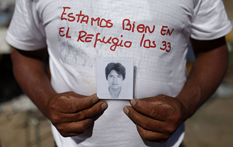 Un familiar muestra la foto de uno de los mineros atrapados.| Ap/Roberto Candia)