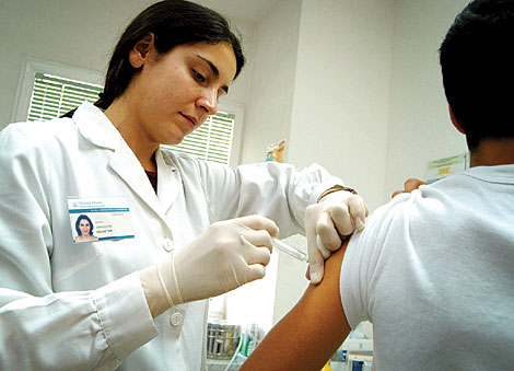 Una enfermera vacunando a un niño.| Roberto Pérez