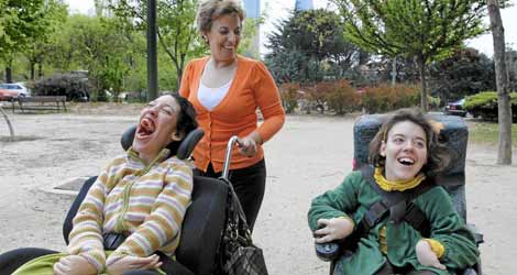 Una mujer pasea con sus hijas, ambas con parálisis cerebral. | Antonio Heredia