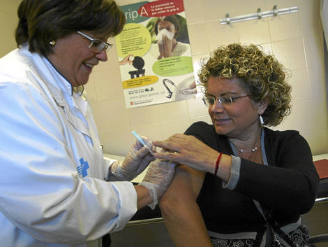 Una doctora vacunando de la gripe a una paciente. | ELMUNDO.es