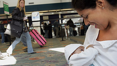 Una mujer amamanta a su hijo en un aeropuerto. | AFP | Roberto Schmidt