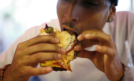 Un hombre comiendo una hamburguesa en Florida. | Reuters