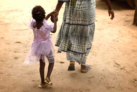 Una madre lleva a su hija de la mano en Senegal. | Reuters