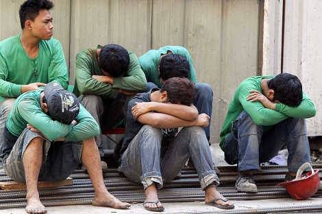 Varios trabajadores echan una cabezada en la pausa de medio da. | Reuters | Erik de Castro