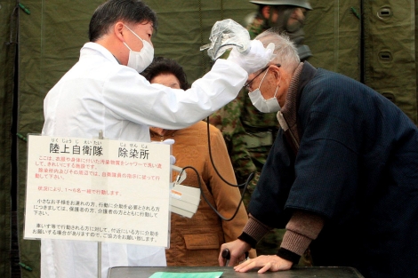 Un médico mide la radiación de un residente de Otama, cerca de Fukushima. | Efe